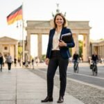 Skilled worker holding documents on a German city street representing Germany Opportunity Card 2026